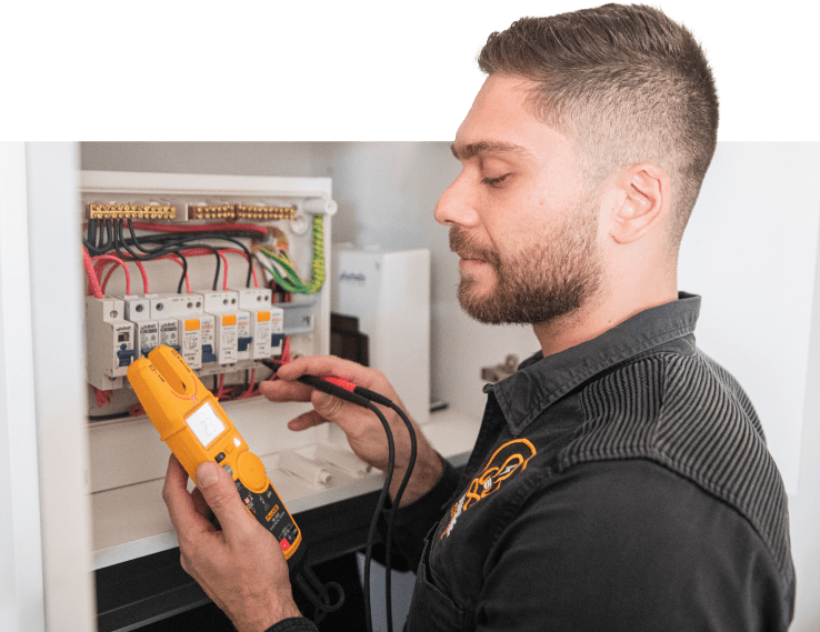 An electrical technician carefully using an electronic multimeter to measure voltage in a circuit.